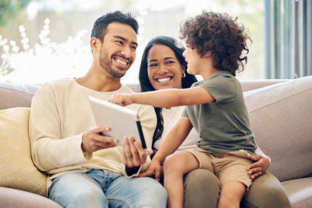 Happy family using Internet at home - watching shows and using laptops together